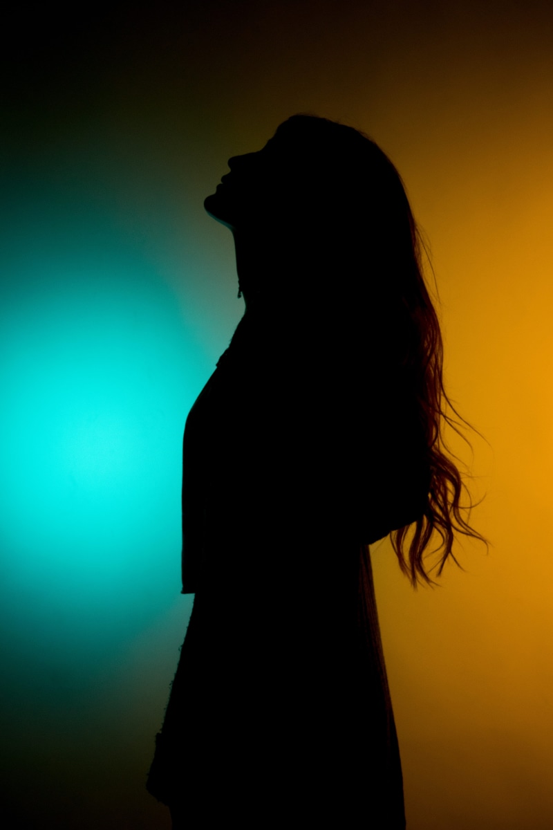 standing, waist up, adult, one person, woman, beautiful woman, women, orange color, silhouette, hairstyle, top - garment, colour backdrop, backlit, colored background