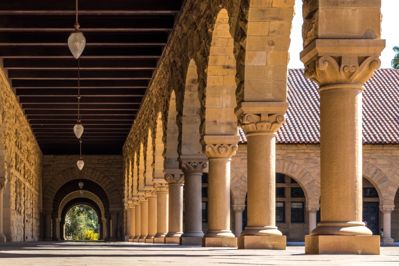 in a row, pillar, hallway, shadow, university, built structure, ceiling, angle, sunlight, day, ornate, roof, travel destinations, low, stone, religion