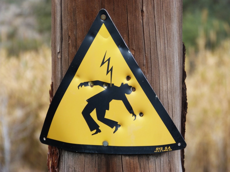 protection, sign, wood, human representation, close-up, safety, information, no people, power line, warning sign, hazard, electric shock, wooden post, yellow