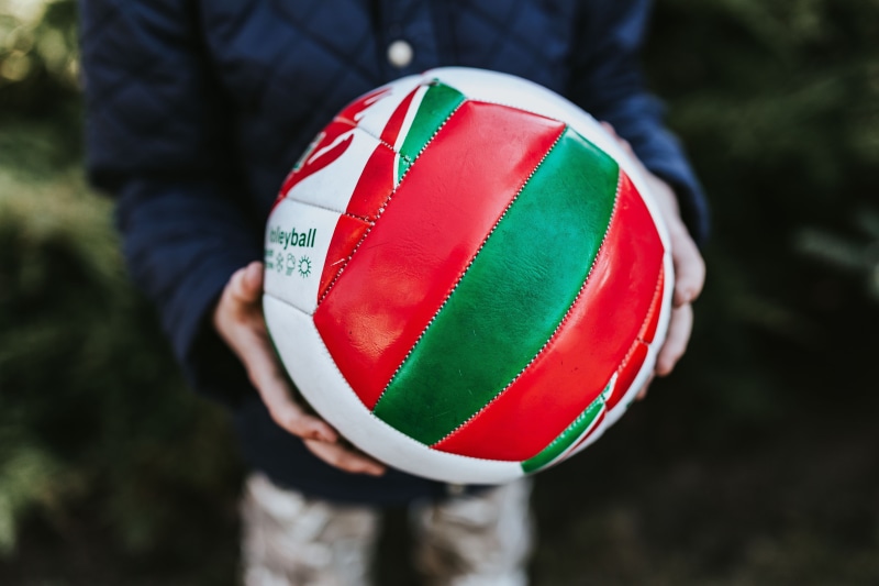 one person, standing, rubiks cube, caucasian Ethnicity, day, sport, ball, jacket, red, holding, real people, casual clothing, playing, human limb, human body part