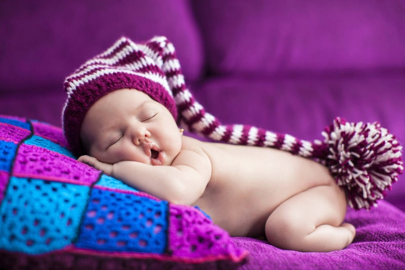 clothing, furniture, sleeping, toddler, beanie, childhood, maroon, purple, baby, relaxation, innocence, babyhood, knitted, cozy, lying down, bed, cute