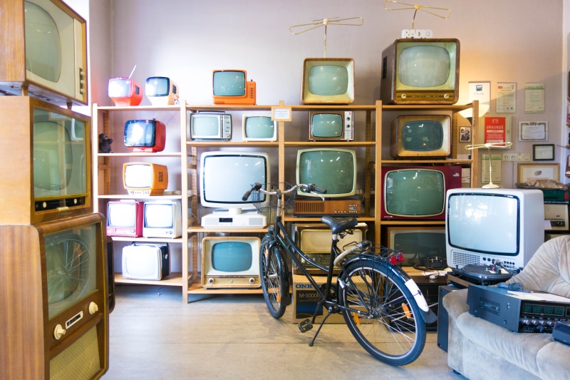 no people, rack, retro styled, bicycle, indoors, near, land vehicle, shelves, vintage, television, lot, screen, old, choice, tvs, mode of transportation