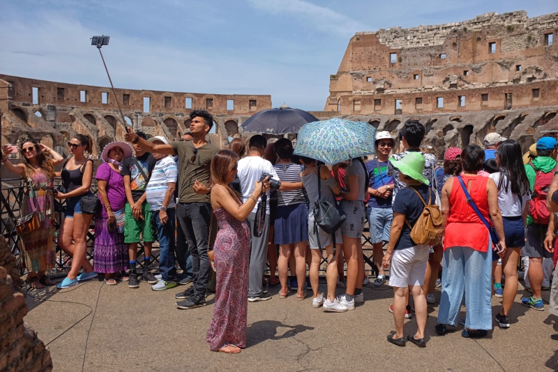 large group of people, selfie stick, building exterior, italy, people, hot, adult, sky, city, rome, mixed age range, real, built structure, attraction