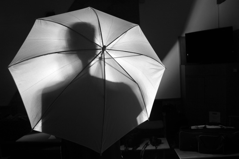 black background, holding, paper, single object, black and white, white, person, unbrella, protection, 4K, dark, group, box, abundance, indoors, close-up