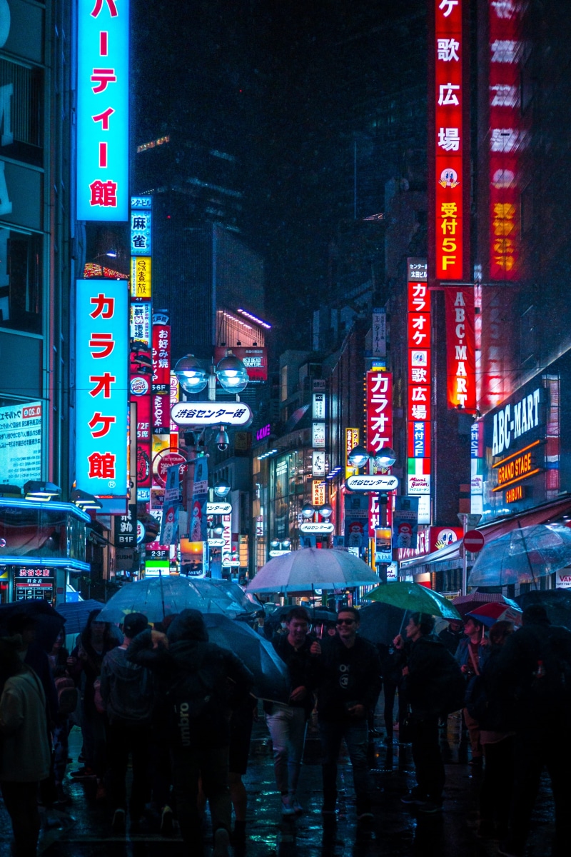 commercial sign, walking, night, neon city, nighttime, communication, rain, building exterior, group of people, sidewalk, 4K, umbrella, neon night, nightlife