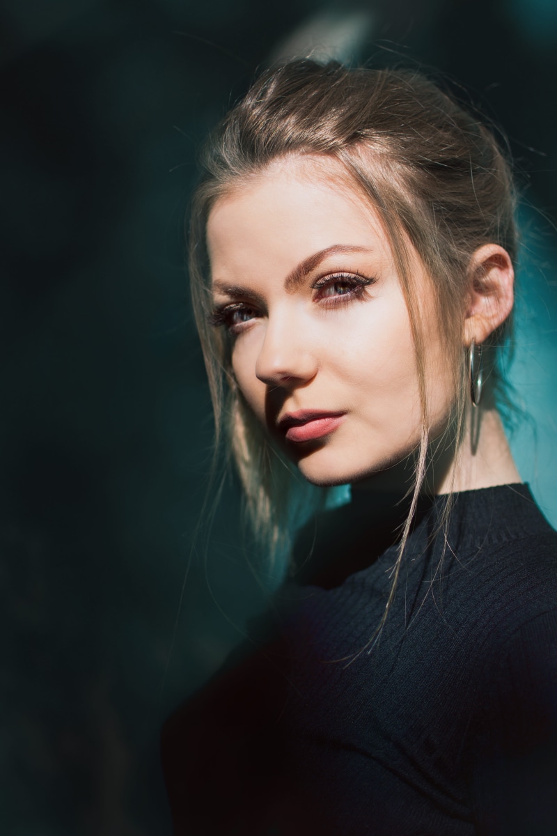 earring, sweater, one person, dark, sunny, light, lost place, long hair, looking at camera, standing, headshot, eye, near, crew, adult, fashion, portrait