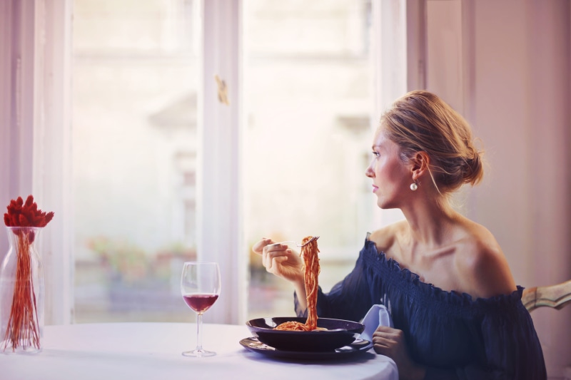 hair, young adult, indoors, off shoulder, plate, happiness, dish, room, food, restaurant, italian, sitting, spaghetti, blur, lunch, red wine, eating, lifestyles