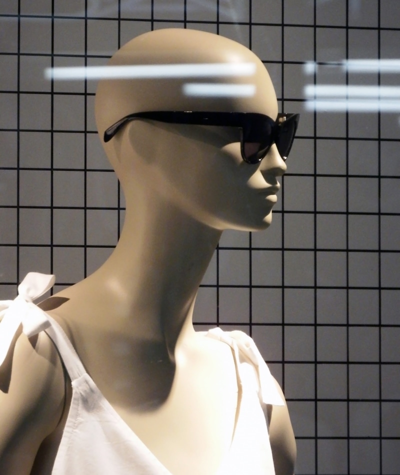 indoors, lay figure, female likeness, glasses, trendy, shopping, fashion, grey, window, shop, background, human representation, light, city, flooring, close up