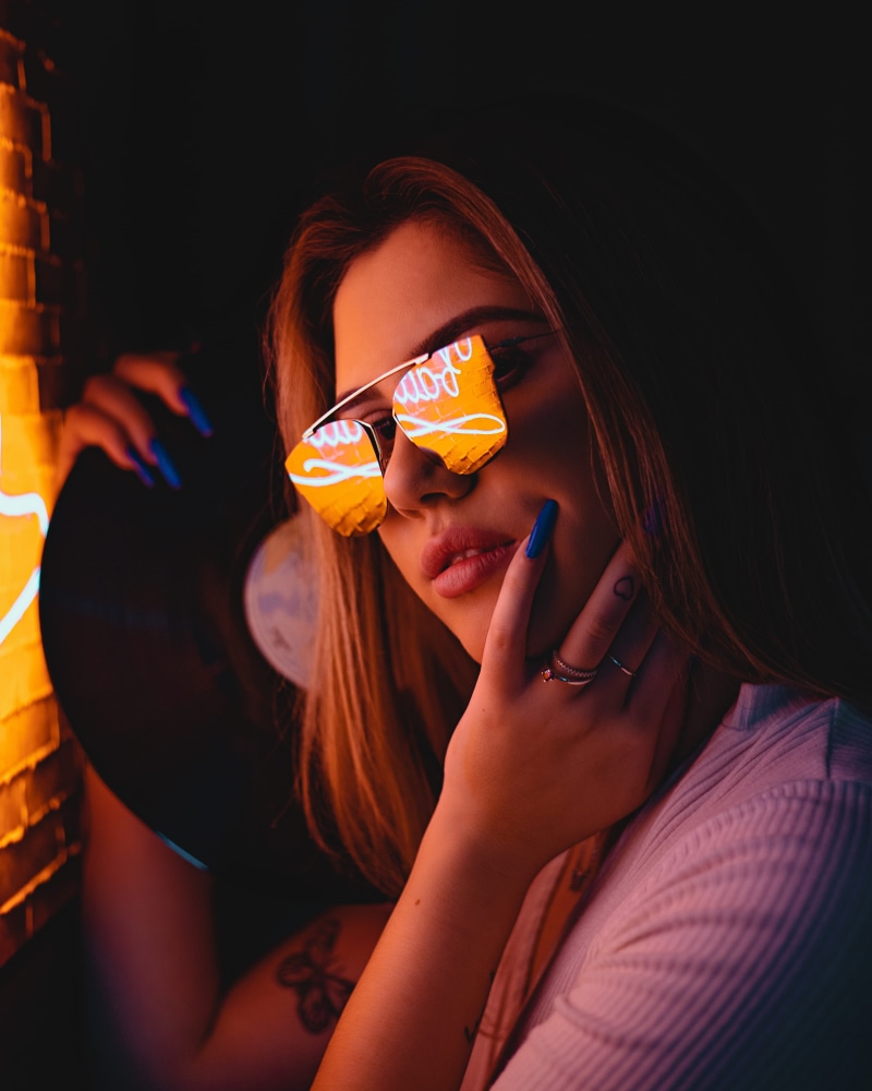 leisure activity, posing, sunglasses, female, pretty, pose, style, close-up, adult, tattoo, neon light, people, woman, beauty, looking at camera, holding