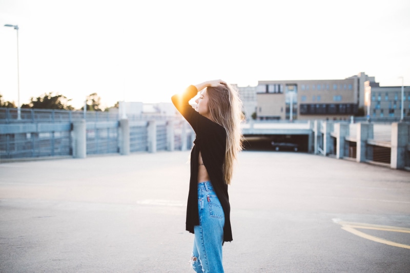 one woman only, standing, beautiful, blue denim, fixing, girl, females, architecture, portrait, young women, hairstyle, shirt, contemplation, sweater, three quarter length