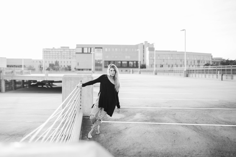 girl, one woman only, wearing, females, leaning, grayscale, holding, adult, day, city, full length, woman, walking, side view, caucasian Ethnicity, photo