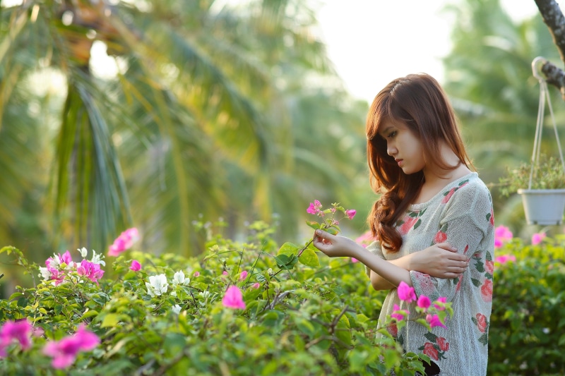 pink, plants, brunette, serious, gardening, looking down, growth, hair, innocence, leisure, dress, sad, look, girl, day, looking, beauty in nature, woman