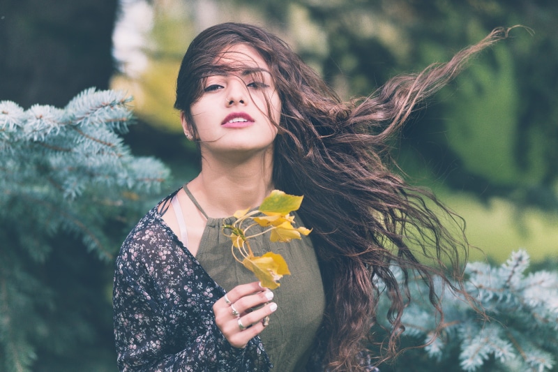 standing, only women, portrait, holding, strap, yellow, adult, plant, women, nature, happiness, front view, adults only, outdoors, brown Hair, shirt, beautiful woman