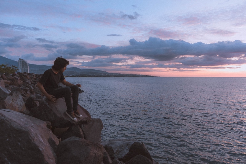 side view, retro, beach, one person, 5K, grunge, rock - object, water, rock, nature, cloud - sky, scenics - nature, leisure activity, sunset, vintage