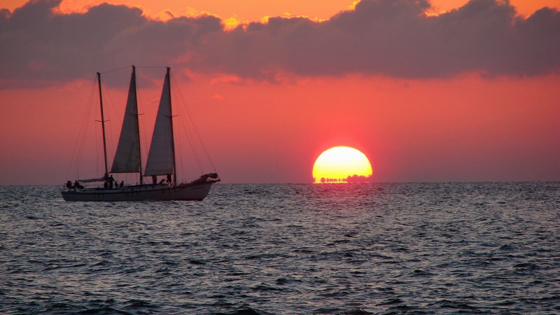 cloud, sea, dawn, transportation, sunrise, no people, water, yacht, sunlight, sailboat, yellow, tranquil, coast, beauty in nature, tree, clouds, scene