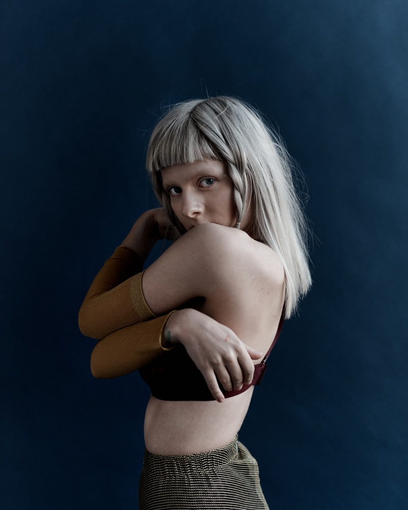 music, human arm, blue background, young women, hairstyle, young adult, human limb, human hair, hair, one person, human body part, body part, portrait