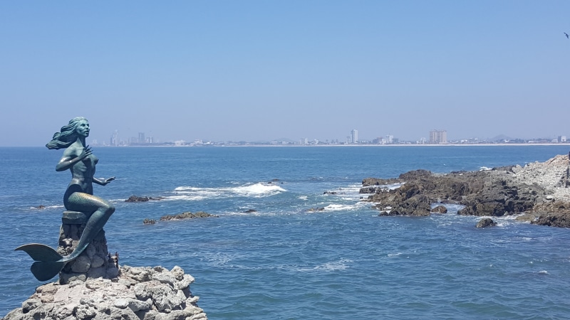 city, outdoors, islet, statue, coastline, tourist destination, day, mermaid, sunlight, no people, gray, sea, military, mazatlan mexico, sculpture, blue
