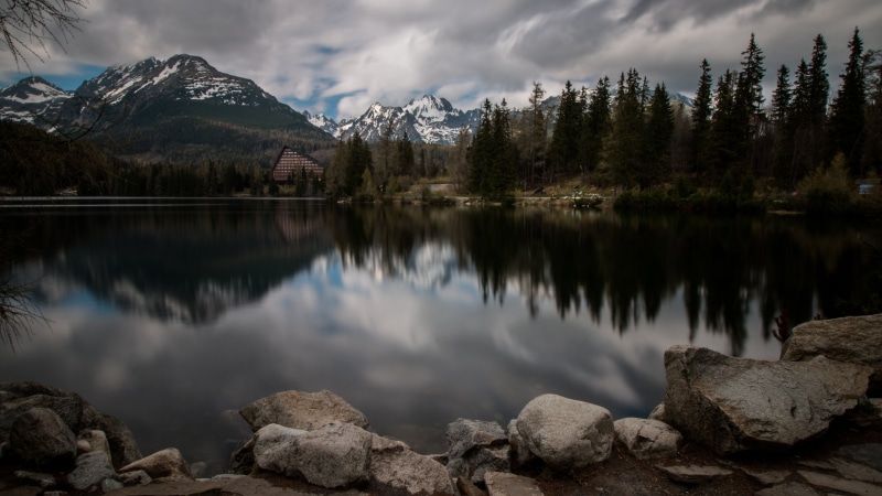 snowcapped mountain, mountain, cloud - sky, reflection lake, tree, tranquility, pine woodland, solid, tourism, outdoors, rock, plant, travel, beauty in nature