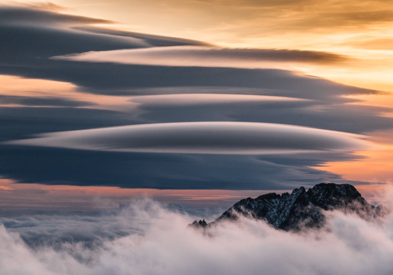 tranquility, beauty in nature, mountain, awe, idyllic, lenticular clouds, outdoors, birds eye view, sunset, landscape, cloud - sky, mountain range, clouds