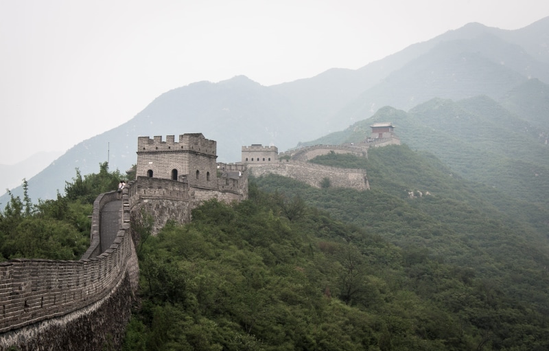 outdoors, mountain range, iconic landmark, day, building exterior, fog, plant, badaling shuiguan great wall, mountain ridge, great wall, architecture, icon
