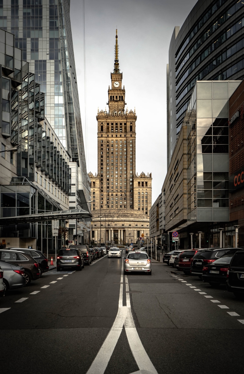 street, tower, motor vehicle, city street, poland, city, car, skyscraper, mode of transportation, office building exterior, clock, building exterior, tall - high