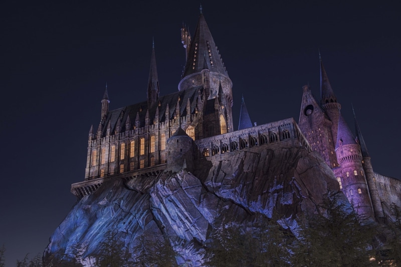 religion, sky, angle, lighted, built structure, architecture, gray, night, cliff, illuminated, trees, travel destinations, Hogwarts, travel, castle, gothic style