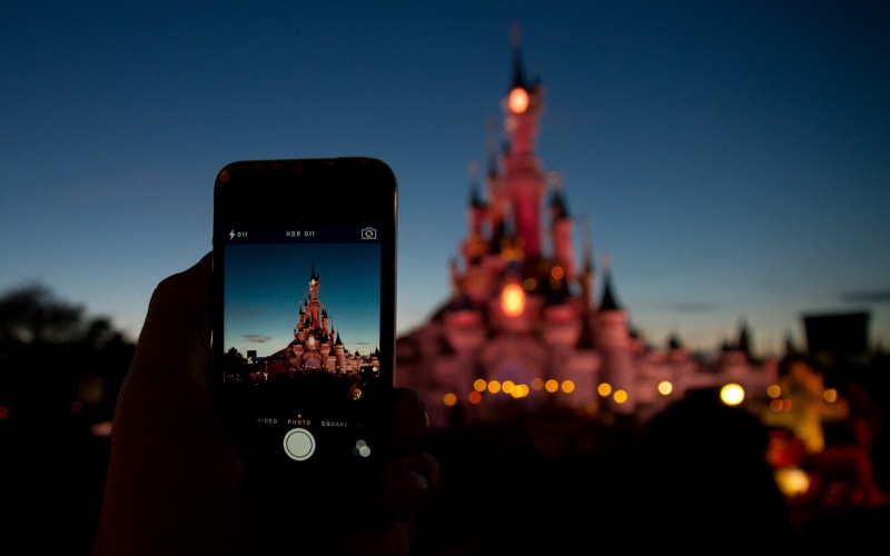 Disney, paris, office building exterior, smart phone, communication, wireless technology, human hand, technology, illuminated, photographing, holding, skyscraper
