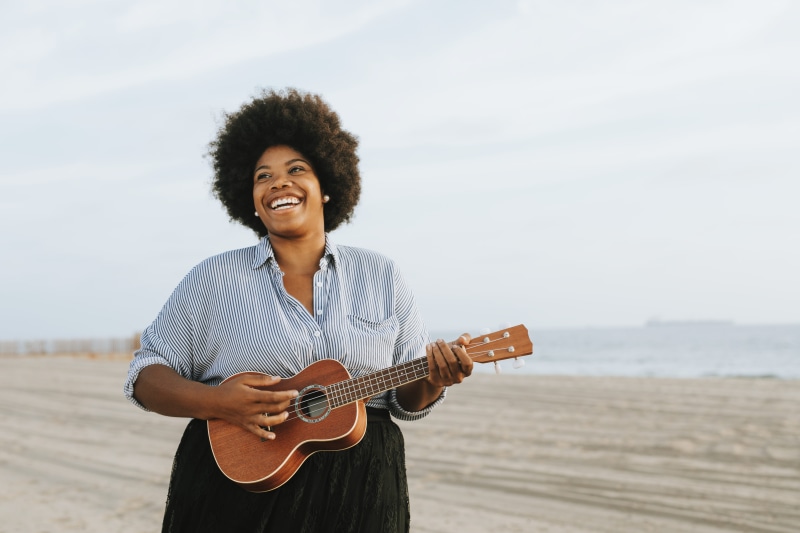 portrait, afro, leisure activity, blue sky, standing, strumming, arts culture and entertainment, weekend, outdoors, water, musical instrument, holding