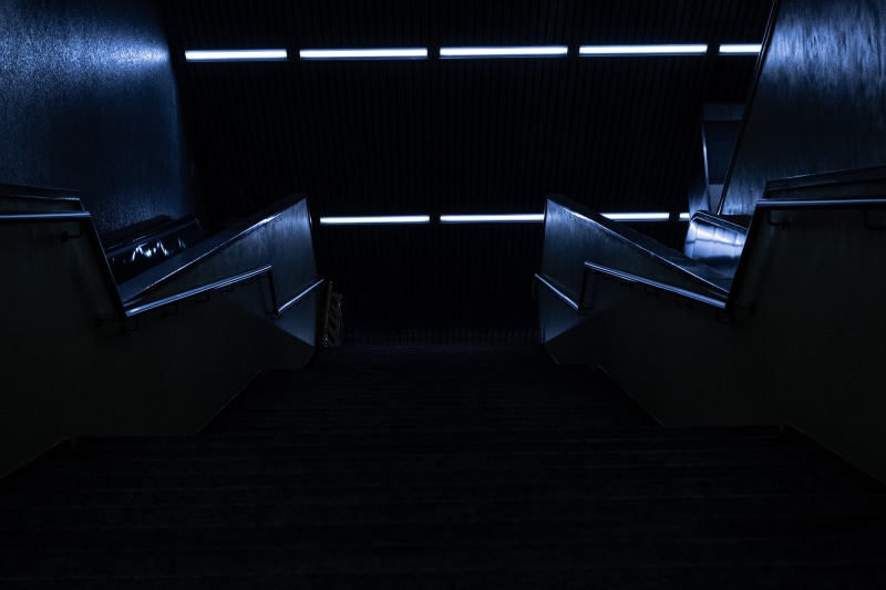 steel, basement, stairs, cologne, railing, arcade game machine, subway, staircase, dark, lighting equipment, the way forward, underground, empty, steps and staircases