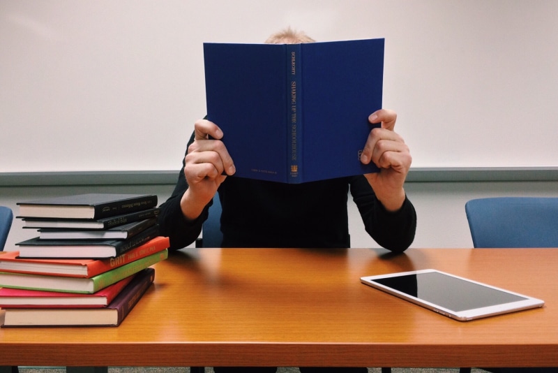 indoors, person, wooden, one man only, literature, activity, reading, humor, hardcover book, paper, human body part, obscured face, males, read, holding