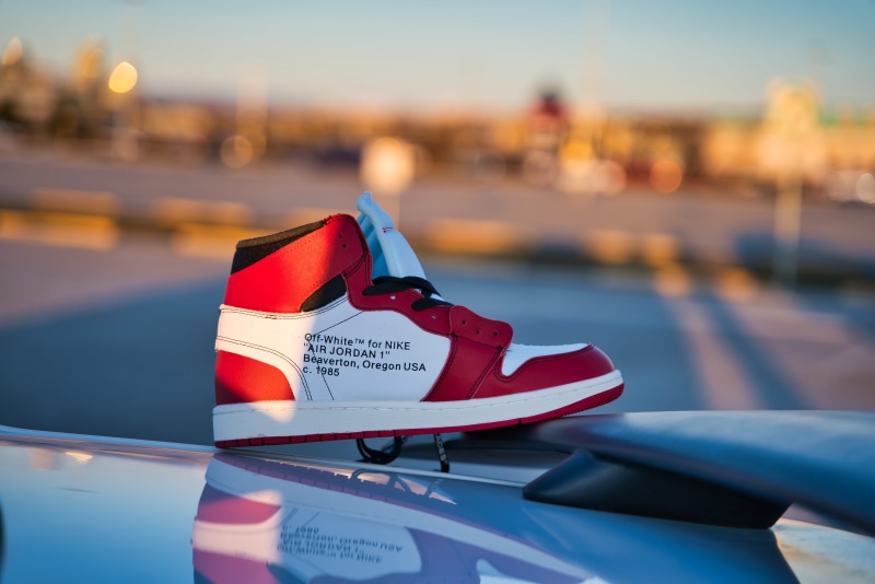 close-up, text, footwear, security, off white, outdoors, white, tire, water, western script, air, running shoe, focus on foreground, city, nike, day, mode of transportation