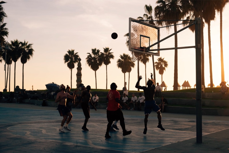 playing, leisure activity, venice beach, shoe, tree, teamwork, lifestyles, plant, people, togetherness, apparel, basketball court, person, working out