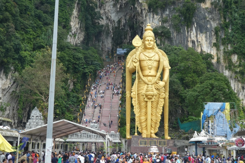 tree, statue, tourism, travel, plant, outdoors, hindu, batu caves, large group of people, kong kuala, representation, male likeness, spirituality, group of people