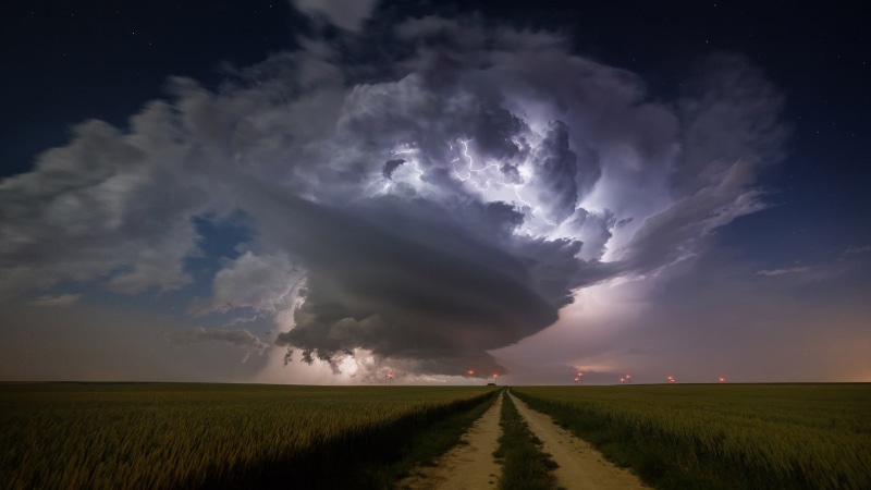 no people, horizon over land, thunderstorm, field, extreme weather, rural scene, road, lightning, dirt road, lights, nature, cloud - sky, landscape, wind farm