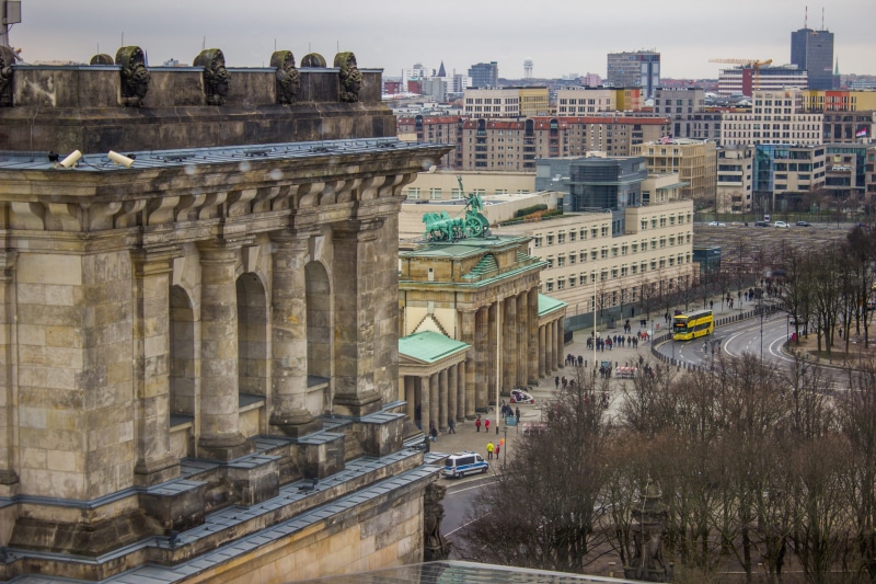 history, brandenburg gate, outdoors, architectural column, perspective, street, building exterior, nature, water, germany, gate, built structure, skyline