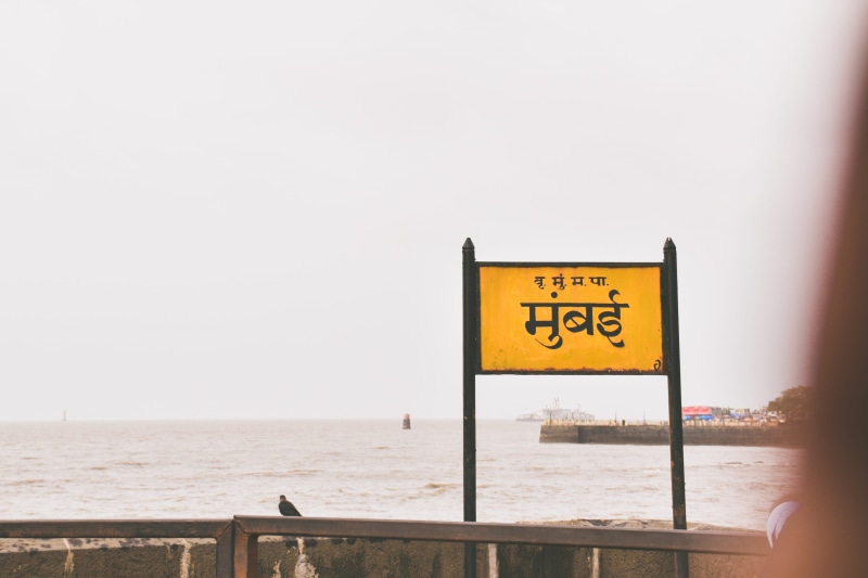 outdoors, sign, message, copy space, western script, 5K, clear sky, built structure, sea, sky, bombay, hindi, water, nature, horizon over water, one person