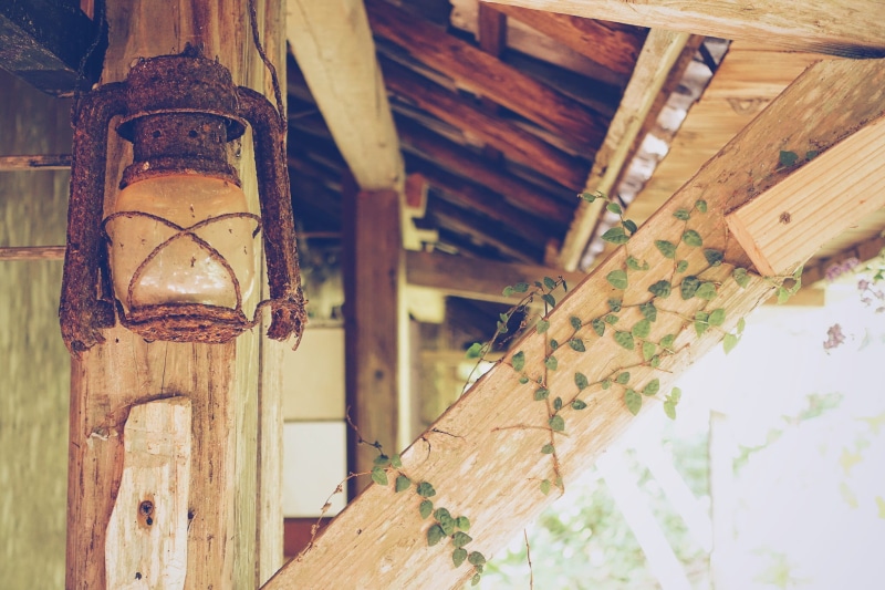 low angle view, hanging on, no People, dirty, close-up, roof, focus on foreground, kerosene, old, still life, post, indoors, day, building exterior, wood - Material