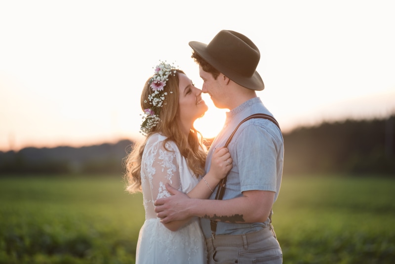 grass, plant, hair, shirt, mid adult, hat, married, caucasian, couple, gray, romance, young women, focus on foreground, facing, background, cheerful, summer