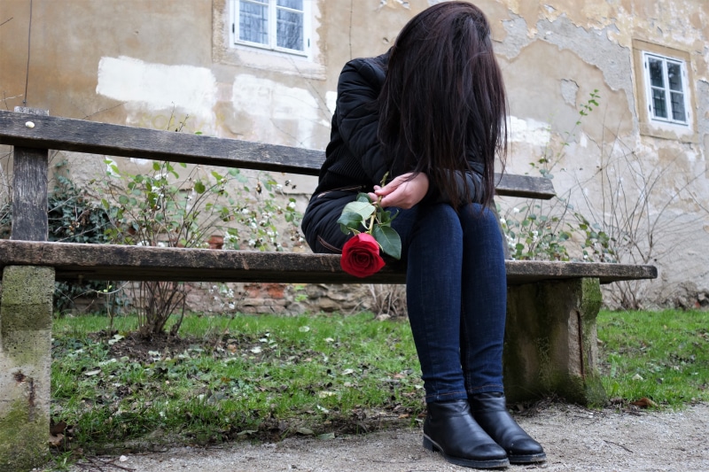 architecture, casual clothing, red rose, young adult, clothing, drama in castle, sitting, sad girl, plant, standing, built structure, bench, hair, lonely