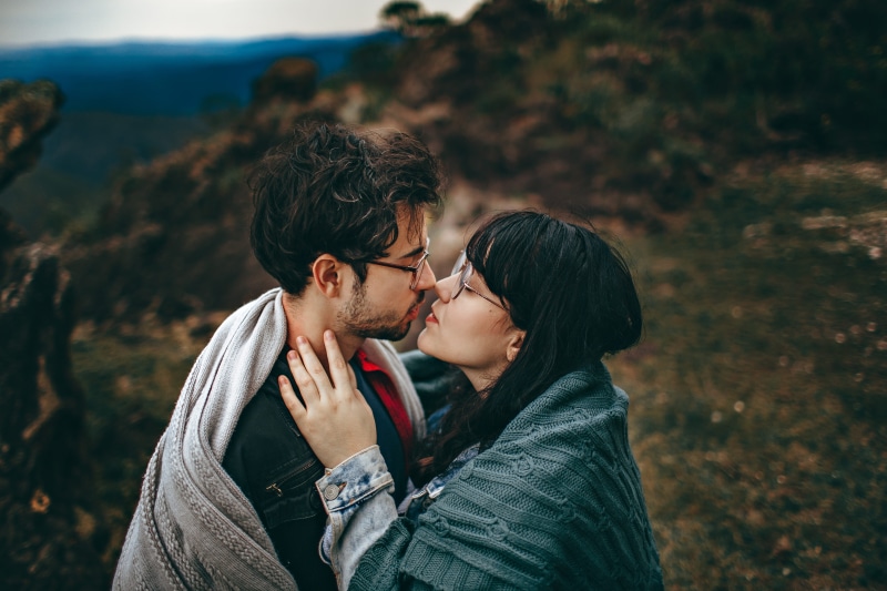 young adult, young man, standing, casual clothing, eyewear, focus on foreground, couple, love, young couple, soulmate, nature, blanket, togetherness, touching noses