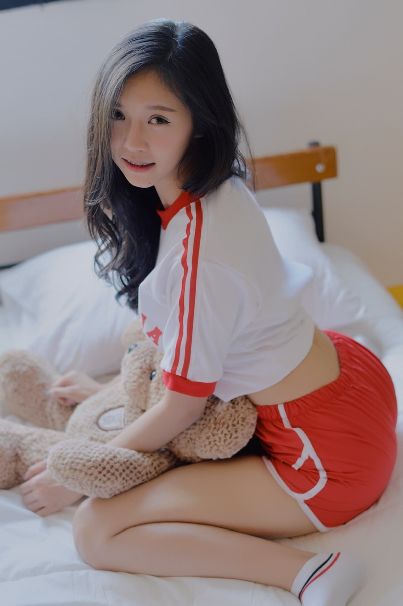 short shorts, indoors, looking at viewer, socks, kneeling, smiling, dark hair, 1080P, long hair, women indoors, portrait display, brunette, model, in bed