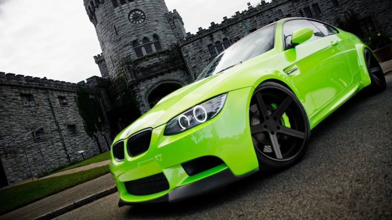 land vehicle, nature, motor vehicle, BMW M3 , no people, flag, architecture, outdoors, communication, green color, city, sky, wall, BMW, green cars, mode of transportation