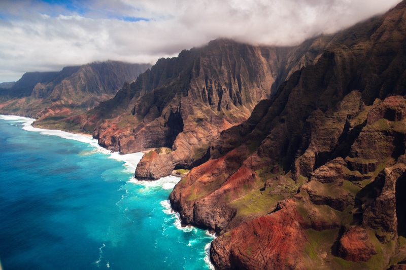body, beauty in nature, sky, cloud - sky, shoreline, green, rock formation, mountain range, promontory, coast, brown, jagged, non-urban scene, solid, scenics - nature