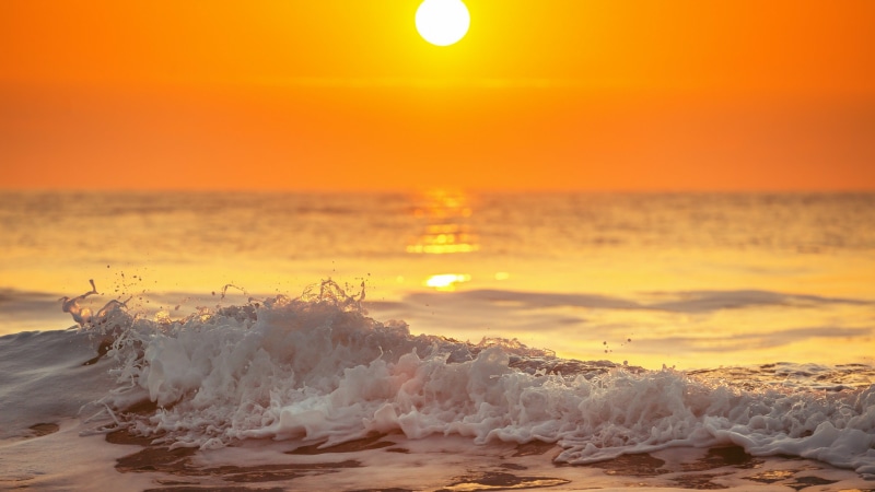 nature, scenics - nature, orange sky, calm, beauty in nature, motion, water, shore, breaking, ocean, sunrise, aquatic sport, surfing, horizon over water