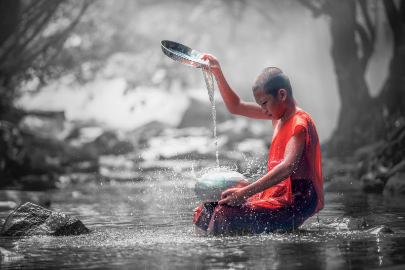 one person, river, women, one woman only, rain, stream - flowing water, ancient, adult, red, orange, buddhism, water, young adult, sport, robe, outdoors