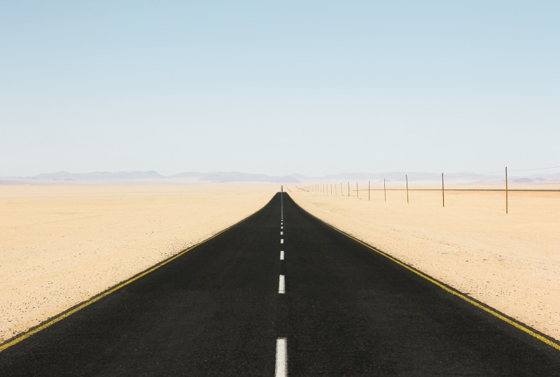 sand, table, clear sky, horizon, dividing line, sign, mountains, diminishing perspective, scenics - nature, transportation, black, environment, road, white