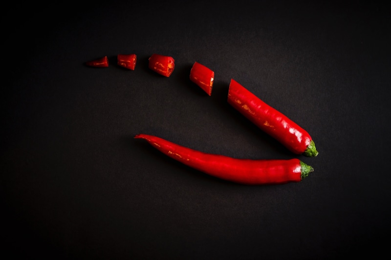 black background, food, pepper, spice, seasoning, cooking, still life, group of objects, no people, ingredient, studio shot, peppers, indoors, paprika