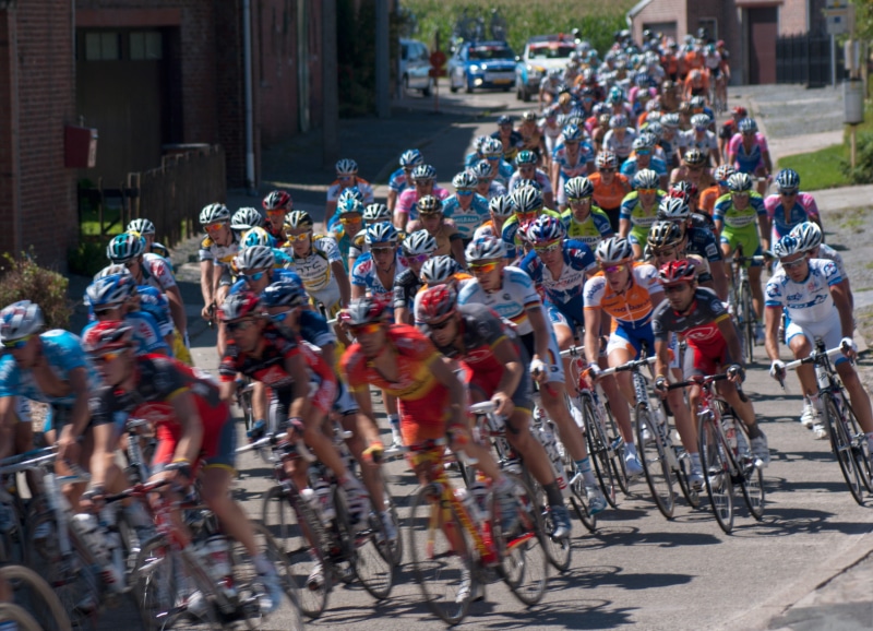 people, cyclists, sports Helmet, street, action, large group of people, built structure, athlete, lifestyles, land vehicle, transportation, city Life, group Of People