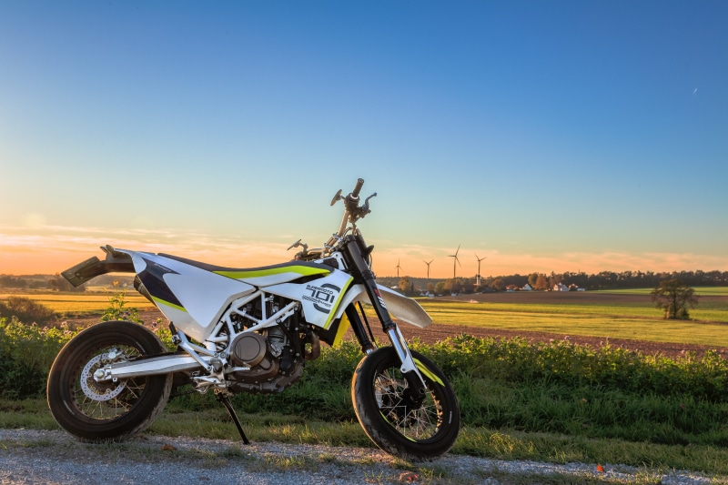sunset, no people, outdoors, transportation, land, motorcycle, field, land vehicle, husqvarna, high quality, blue, day, mode of transportation, stationary