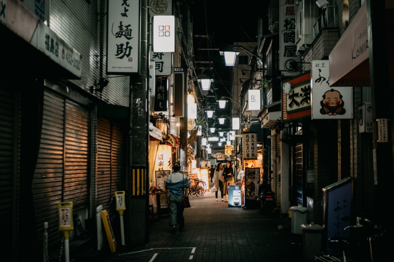incidental people, signs, built structure, light, the way forward, chinese, suburb, architecture, men, people, night, marketplace, closed, person, lifestyles